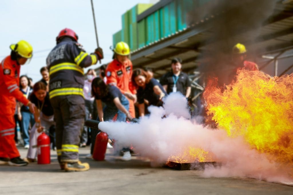 Employés en formation à la lutte contre l'incendie, Concept Employés utilisant à la main un extincteur pour lutter contre l'incendie, gros plan. Pulvérisation d'un extincteur.